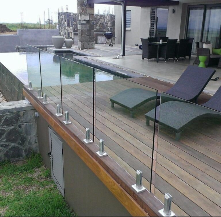 Glass railings with stainless steel spigots on wooden deck with swimming pool
