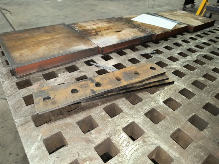 Cut steel components laid out on a fabrication table