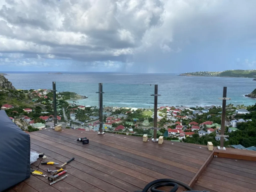 Glass railing installation in progress on a coastal deck